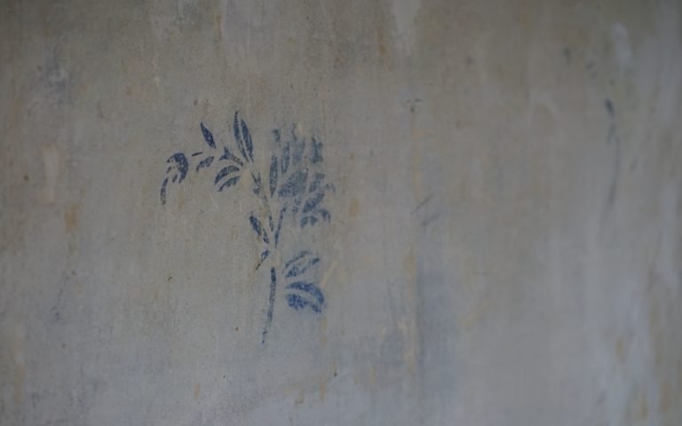 blue flower pattern on a concrete wall